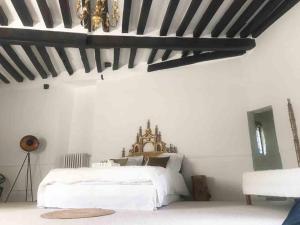 a bedroom with a white bed and a black and white ceiling at Le Saint Leonard in Montceaux-lès-Provins