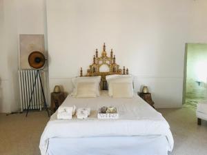 a bedroom with a large white bed with two boxes on it at Le Saint Leonard in Montceaux-lès-Provins