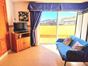 アデへにあるLuis Estudio Adeje Tenerife Surのリビングルーム(青いソファ、大きな窓付)