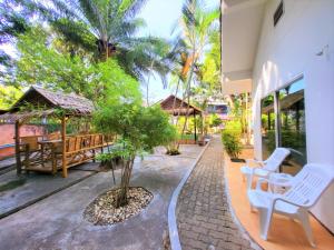 um pátio com uma mesa, cadeiras e árvores em Blue Palm Kata Resort em Kata Beach