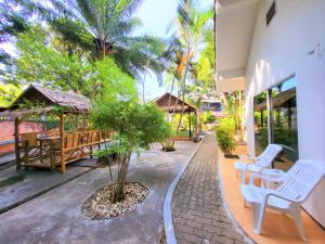 a patio with a table and chairs and trees at Blue Palm Kata Resort in Kata Beach