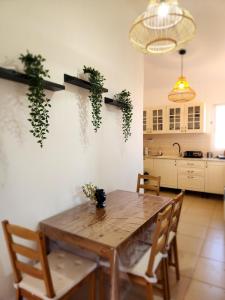 a kitchen with a wooden table with plants on the wall at לוויס פלייס levis place 52 in Eilat
