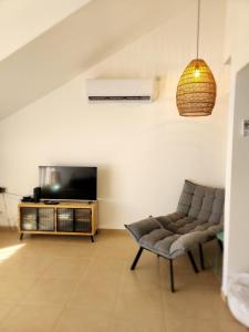 sala de estar con sofá y TV en לוויס פלייס levis place 52 en Eilat