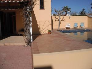 ein Haus mit einem Pool und zwei Stühlen in der Unterkunft Casa familiar con piscina, cerca de la playa in Ciutadella