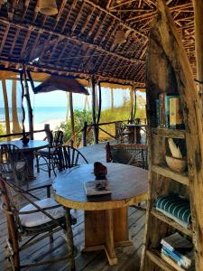 a table in a hut with a view of the beach at Mahali Maalum Barefoot Lodge in Mkwaja