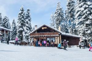 eine Gruppe von Menschen, die vor einem Gebäude im Schnee stehen in der Unterkunft Luxury one bed apartment with hydro bath in Royal Plaza in Borowez