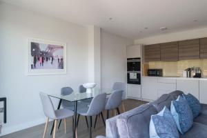 a living room and kitchen with a table and chairs at The Hampstead Hideout - Glamorous 3BDR Flat with Balcony in London