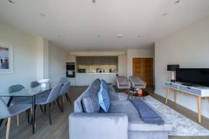 a living room with a couch and a table at The Hampstead Hideout - Glamorous 3BDR Flat with Balcony in London