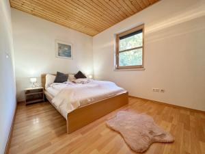 a bedroom with a bed and a window and a rug at Ferienhaus Sonnenberg in Reith bei Seefeld