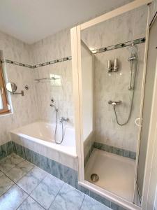 W łazience znajduje się prysznic, wanna i umywalka. w obiekcie Ferienhaus Sonnenberg w mieście Reith bei Seefeld