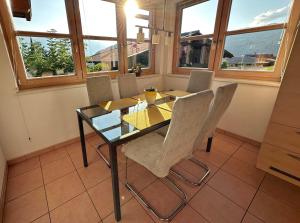 uma sala de jantar com uma mesa de vidro e cadeiras em Ferienhaus Sonnenberg em Reith bei Seefeld