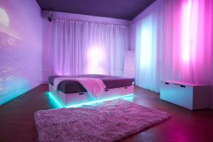 a bedroom with a bed with neon lights and a rug at Huge Apartment with Home Cinema and Kitchen in Friedrichshain in Berlin