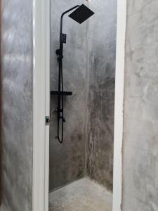 a shower with a shower head in a room at MoRue's Den in Mabini