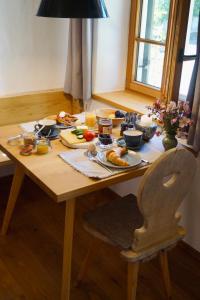 una mesa de madera con comida y una silla en Das Heuhaus, 