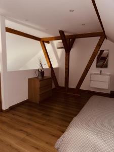 a bedroom with a bed and a wooden floor at Gîte Cosy au cœur de l'Alsace in Roggenhouse