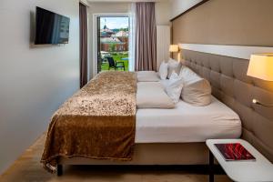 a hotel room with a large bed with a window at Hotel König Albert in Bad Elster