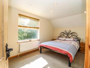 Schlafzimmer mit einem Bett und einem Fenster in der Unterkunft Tembo's Rest in Sandwich