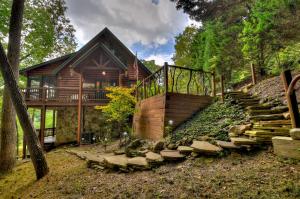 a log cabin with stairs leading to a house at CaBEARnet Creek Cabin - hot tub, pet friendly, fire pit, outdoor fireplace in Morganton