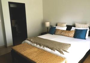 1 Schlafzimmer mit 2 Betten mit blauen und goldenen Kissen in der Unterkunft Private Beach 5-star Villa, Golf & Luxe in Centre de Flacq