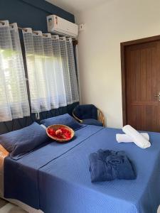 Una cama azul con un tazón encima. en Sapê Guest Hotel, en Praia do Rosa