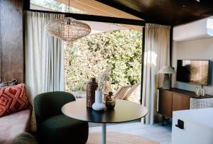 a living room with a table and a couch at Wellness Lodges x De IJsvogel in Voorthuizen