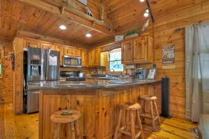 a kitchen with wooden cabinets and a counter top with stools at CaBEARnet Creek Cabin - hot tub, pet friendly, fire pit, outdoor fireplace in Morganton