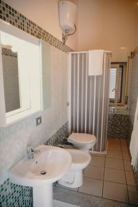 a bathroom with a sink and a toilet at Halykos Hotel in Cammarata