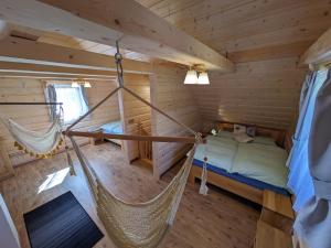 1 dormitorio con hamaca en una cabaña de madera en Malebný chalet Benešky, en Velké Karlovice