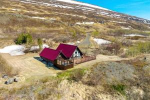 een klein huis met rode daken op een heuvel bij Akureyri Retreat in Akureyri