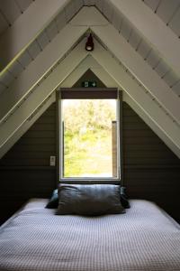 Cama en habitación con ventana en Akureyri Retreat, en Akureyri