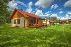 ein Haus mit einem großen Garten mit grünem Gras in der Unterkunft Rentynówka in Gietrzwałd