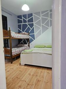 sypialnia z 2 łóżkami piętrowymi i drewnianą podłogą w obiekcie Titi's home Velipoje w mieście Velipoja