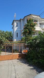 une maison avec une clôture devant un bâtiment dans l'établissement Titi's home Velipoje, à Velipojë