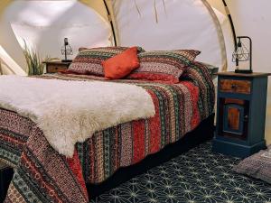 a bed with a comforter and pillows in a room at Eversprings Glamping in Mount Helena