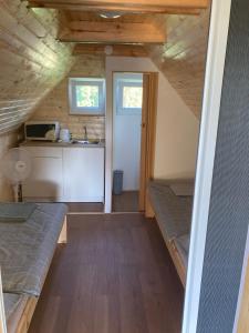 a small room with two bunk beds and a kitchen at Jövő Hét Pihenőház in Poroszló