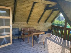 una mesa de madera y sillas en una terraza en Jövő Hét Pihenőház en Poroszló