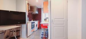 cocina con TV grande y taburete rojo en Bellerive, pieds dans l'eau lac & montagnes, en Publier