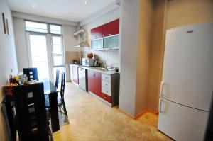 eine Küche mit einem Tisch und einem weißen Kühlschrank in der Unterkunft Tbilisi Sweet Home in Tbilisi City
