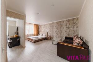 ein Hotelzimmer mit einem Bett und einem Schlafzimmer in der Unterkunft Однокомнатная квартира в центре Лото in Petropawlowsk