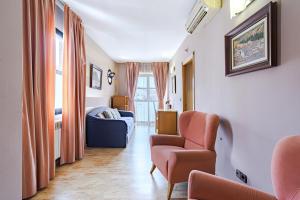 a living room with a couch and chairs in a room at Hostal Don Juan in Meco