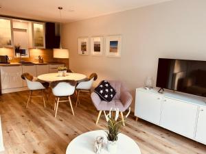 a kitchen and living room with a table and chairs at Westend Amelander Kaap 85 in Hollum