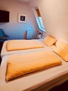 two beds in a hotel room with yellow sheets at Westend Amelander Kaap 85 in Hollum