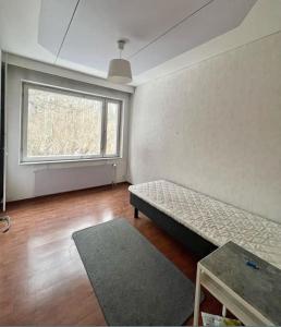 an empty room with a bed and a window at Kotimaailma - Tilava rivitalo asunto 3MH ja sauna lähellä Korson keskustaa in Helsinki +3 photos