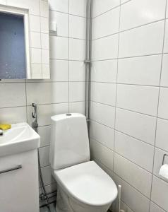 a white bathroom with a toilet and a sink at Kotimaailma - Tilava rivitalo asunto 3MH ja sauna lähellä Korson keskustaa in Helsinki