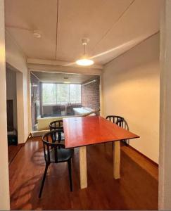 a dining room with a wooden table and chairs at Kotimaailma - Tilava rivitalo asunto 3MH ja sauna lähellä Korson keskustaa in Helsinki