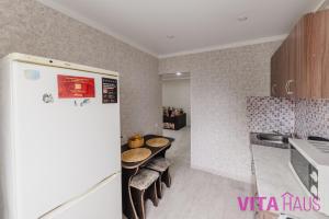 eine Küche mit Tisch und Kühlschrank in der Unterkunft Однокомнатная квартира в центре Лото in Petropawlowsk