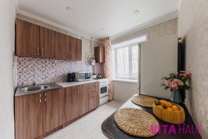 eine Küche mit einem Tisch mit einer Obstschale darauf in der Unterkunft Однокомнатная квартира в центре Лото in Petropawlowsk