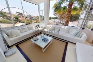 a living room with a white couch and a table at Haidys House - Disfruta de las Vistas al mar in Castelldefels