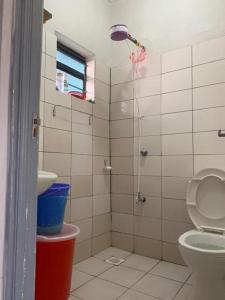 a bathroom with a shower with a toilet and a sink at Lux Suites Rio Vista Executive Studio Apartments in Makandara