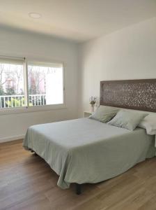 Un dormitorio con una cama grande en una habitación blanca. en Apartamento Reformado con Aparcamiento. Playa 5min a pie., en Platja d'Aro 5 fotos más